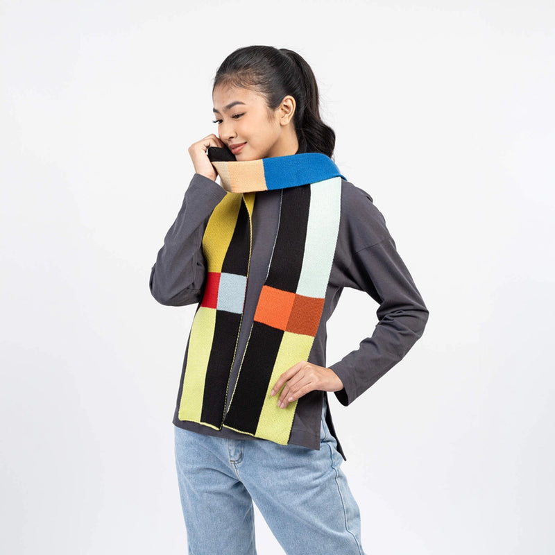 Woman wearing a colorful geometric-patterned scarf on a white background